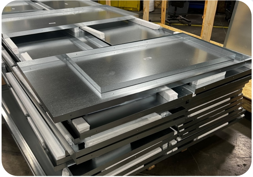 Custom-profile ProSteel curtain wall backpans stacked in the fabrication shop